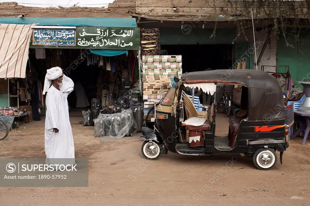A tuk tuk in front of shops at Dongola, Sudan, Africa