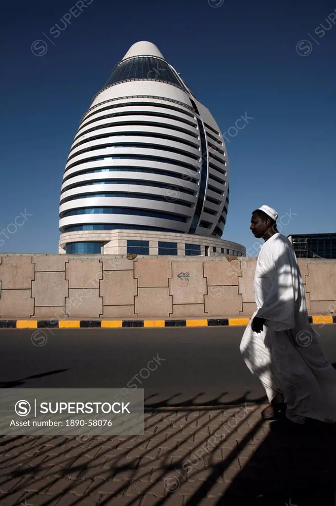 Locals walk past the 5_star Boji Al_Fateh Hotel Libyan Hotel, designed to represent a sail, Khartoum, Sudan, Africa