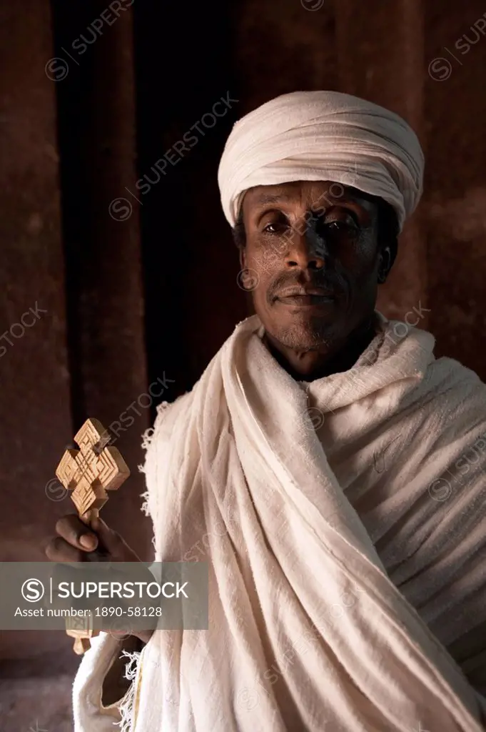 A priest stands at the entrance to the rock_hewn church of Bet Amanuel, in Lalibela, Ethiopia, Africa