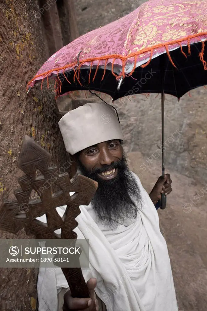 A priest holds a cross at the rock_hewn church of Bet Giyorgis St. George, in Lalibela, Ethiopia, Africa