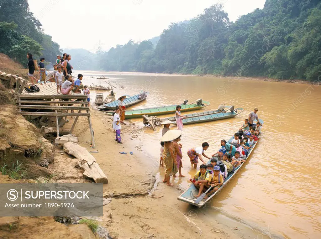Longboat crowded with children leaving for week at school, seen off by their mothers, Katibas River, Sarawak, island of Borneo, Malaysia, Southeast As...