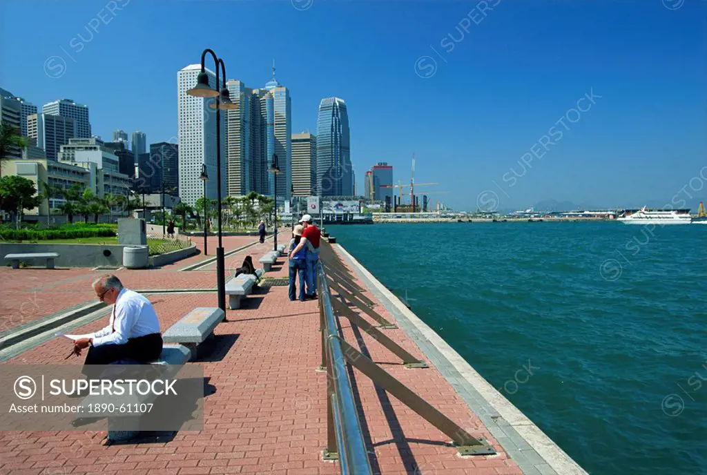 Looking along the waterfront of Victoria Harbour towards the tower blocks of Central, Hong Kong Island, Hong Kong, China, Asia