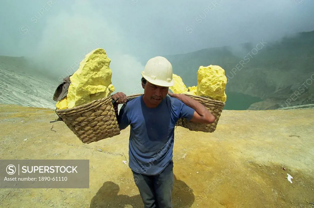 Miner on the crater rim of 2400m volcano of Gunung Ijen in east Java, Indonesia, Southeast Asia, Asia