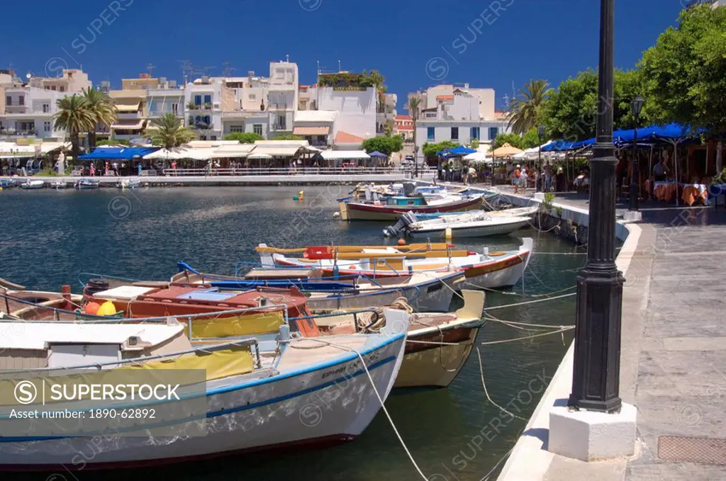Colourful small fishing boats and tavernas surrounding Lake Voulismeni the bottomless lake in Agios Nikolaos Agios Nikolaus, Crete, Greece, Europe