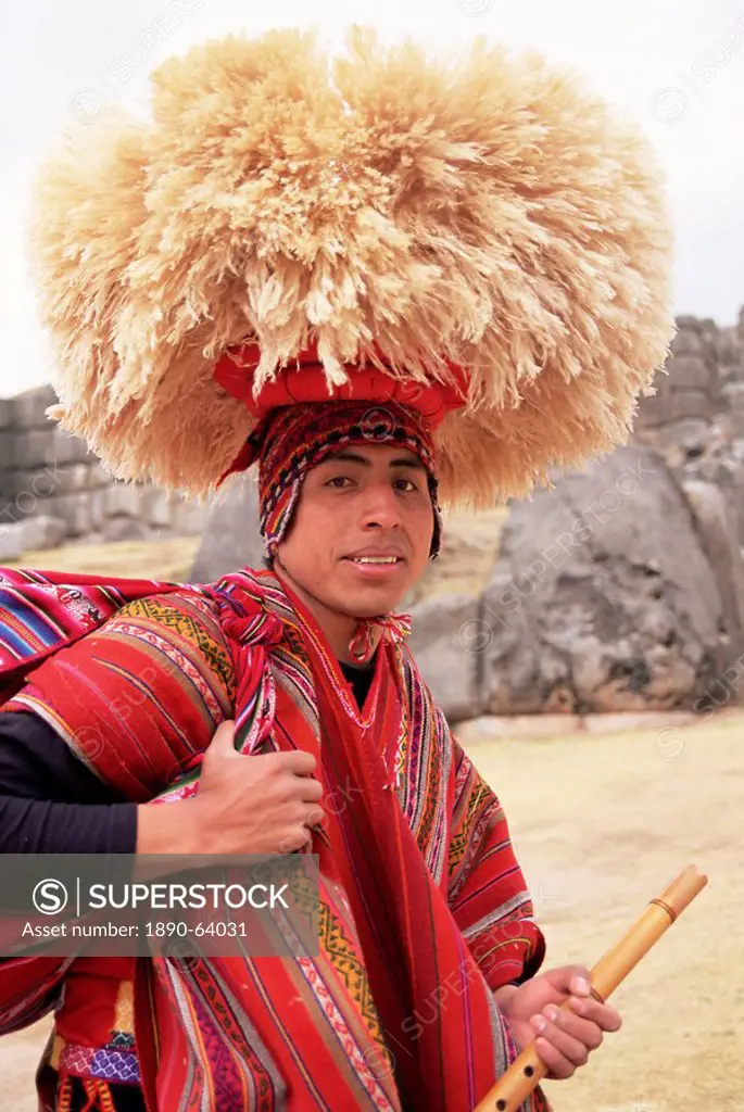 Portrait of a young Peruvian man in traditional dress, with hat and flute, Sacsayhuaman, near Cuzco, Peru, South America