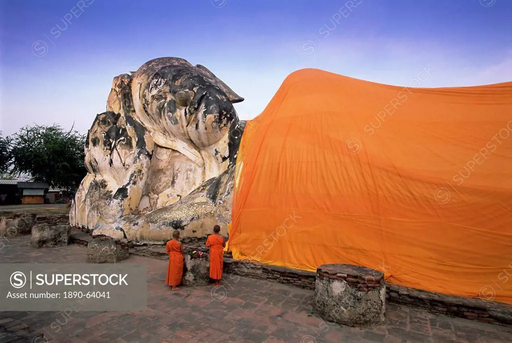 Two novice Buddhist monks in front of a statue of the reclining Budha, Wat Lokayasutharam, Ayuthaya Historical Park, Ayuthaya Ayutthaya, UNESCO World ...