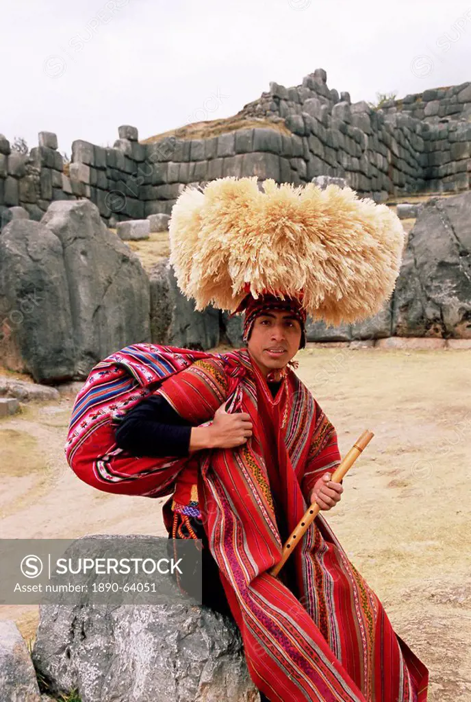 Portrait of a young Peruvian man in traditional dress, with a flute, Inca ruins of Sacsayhuaman, Cuzco, Peru, South America
