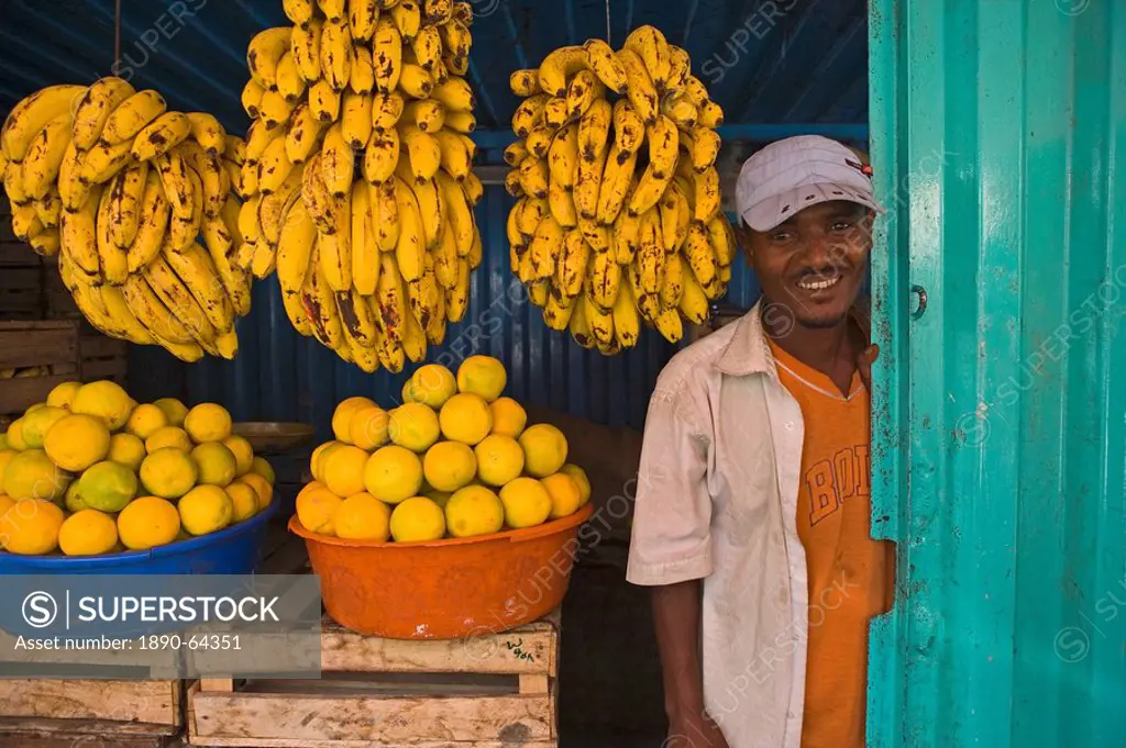 man standing next to Bananas in a market stall in Gonder, Gonder, Ethiopia, Africa