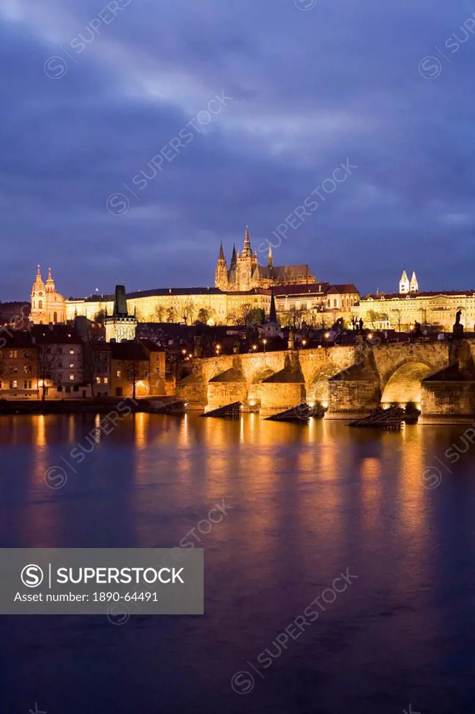 St. Vitus Cathedral, Charles Bridge and the Castle District illuminated at night in winter, seen from across the Vltava River, Prague, Czech Republic,...