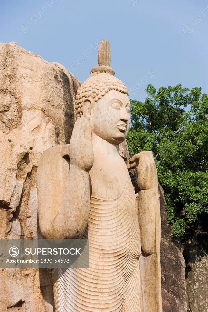 Giant standing statue of the Buddha, his right hand raised in blessing, the left hand lifting the robe symbolising reincarnation, Aukana, Sri Lanka, A...