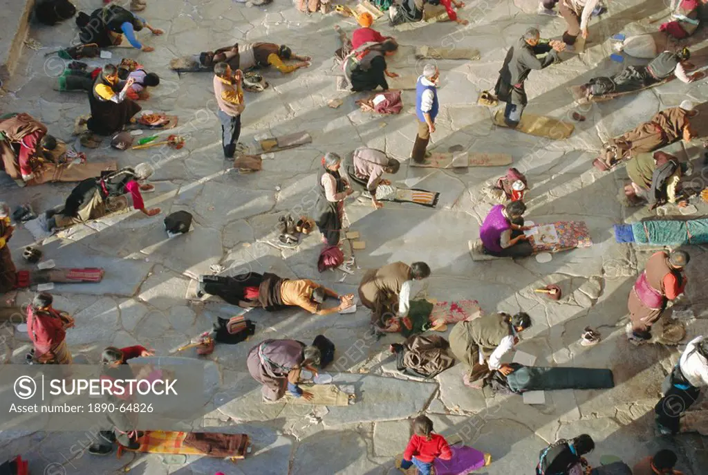 Buddhist pilgrims prostrating, Barkhor Jokhang Temple, Lhasa, Tibet, China