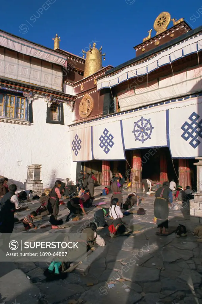 Tibetan Buddhist pilgrims prostrating in front of the Jokhang temple, Lhasa, Tibet, China, Asia