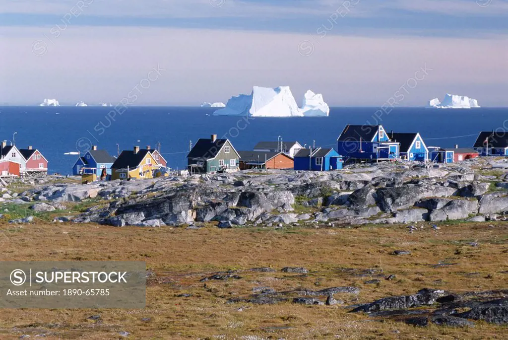Painted village houses in front of icebergs in Disko Bay, Oeqertarsuaq Godhavn, Disko island, west coast, Greenland, Polar Regions