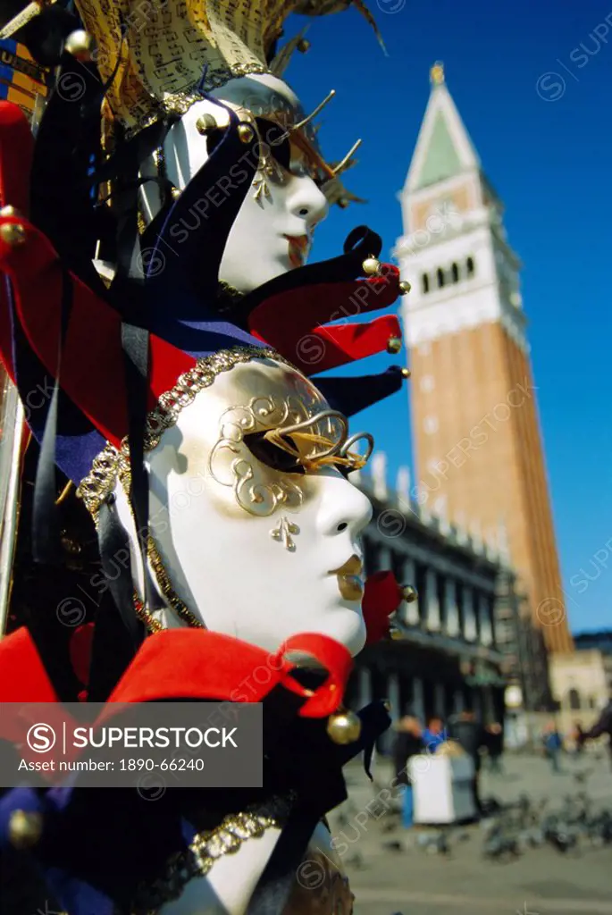Carnival masks on souvenir stand and Campanile, St Marks Square, Venice, Veneto, Italy