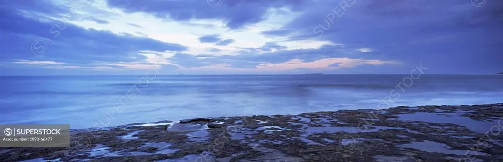 View across North Sea towards Farne Islands at dusk, from Bamburgh, Northumberland Northumbria, England, United Kingdom, Europe