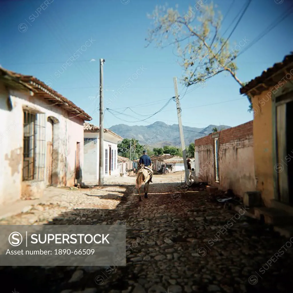 Street scene with man on horseback, Trinidad, Cuba, West Indies, Central America