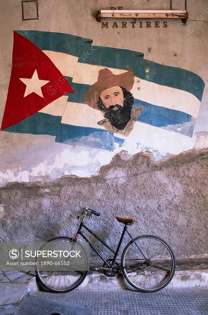 Mural of Camilo Cienfuergos on wall above a bicycle, Havana, Cuba, West Indies, Central America
