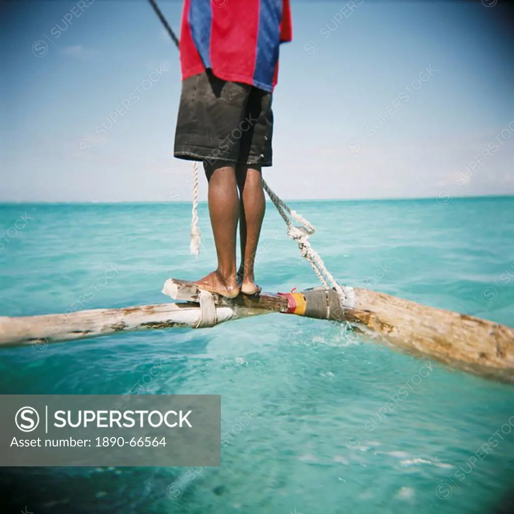 Man standing on outrigger in Indian Ocean, Zanzibar, Tanzania, East Africa, Africa