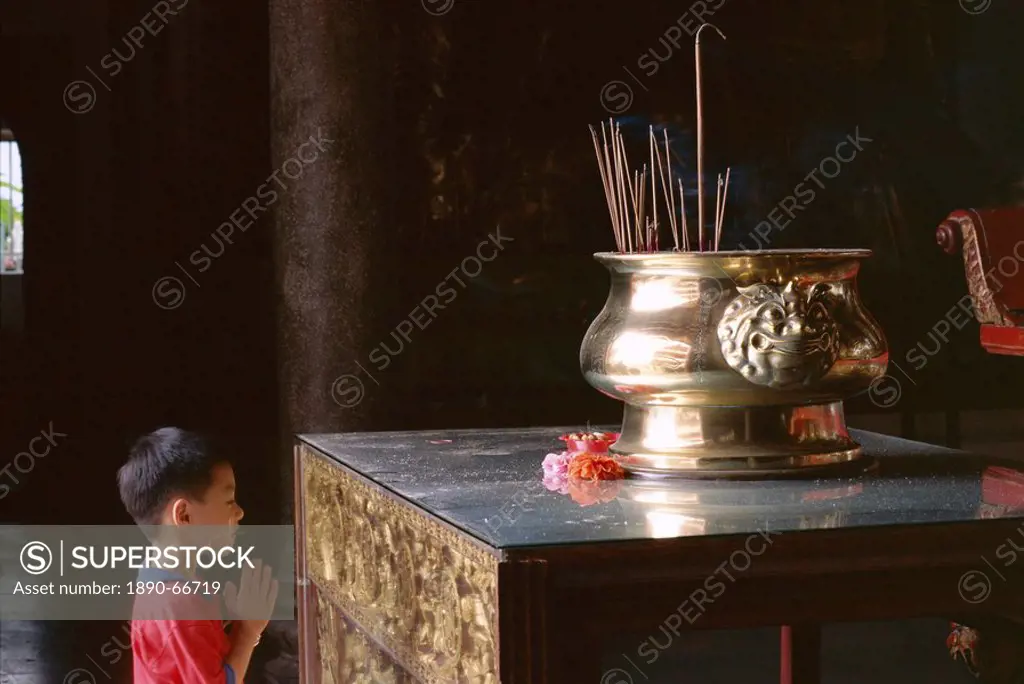 Boy praying at Kek Lok Si Temple, Penang, Kuala Lumpur, Malaysia, Asia