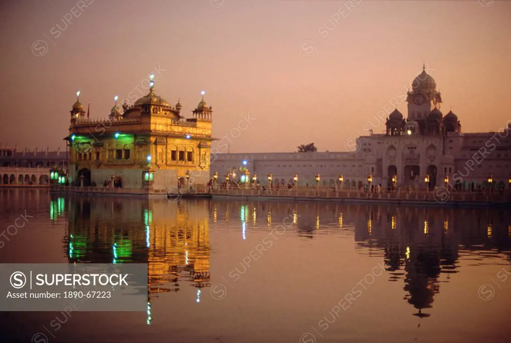 Dusk over the Holy Pool of Nectar looking towards the clocktower and the Golden Temple, Sikh holy place, Amritsar, Punjab State, India, Asia
