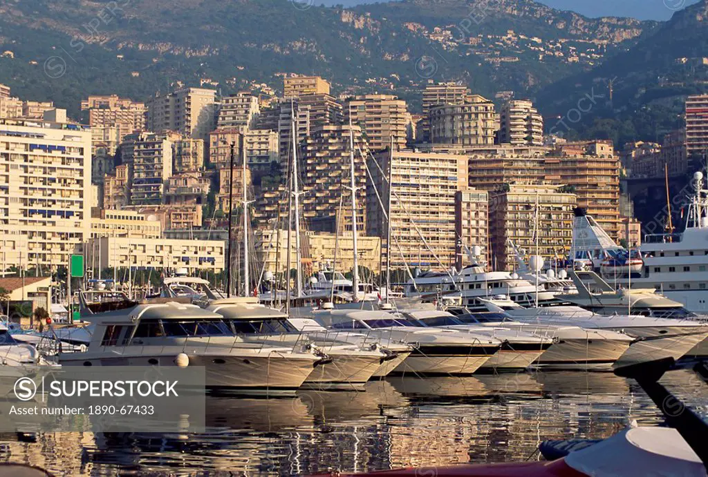 Motor cruisers at anchor and highrise buildings above the harbour, La Condamine, Monaco, Mediterranean, Europe
