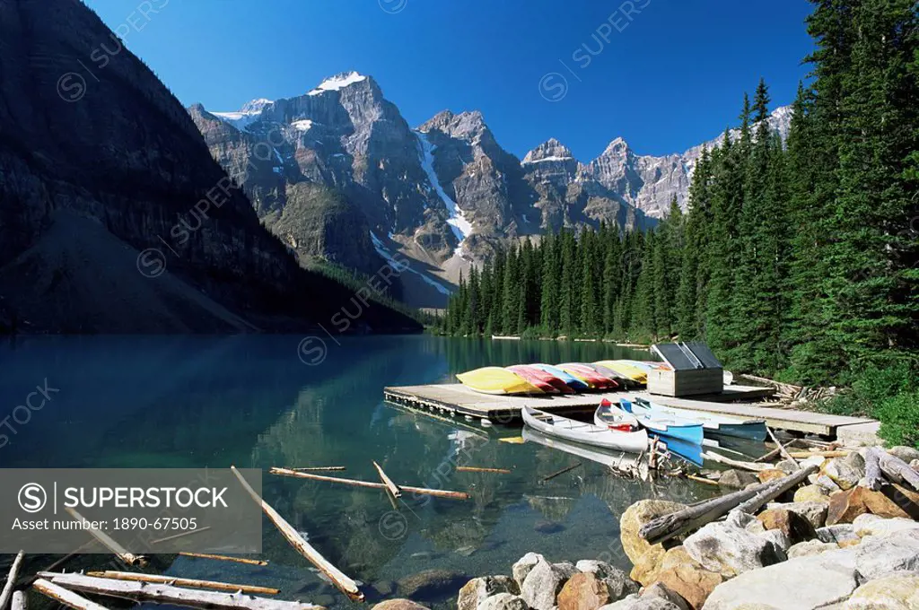 Canoes for hire on shore of Moraine Lake, with view to the Wenkchemna Peaks, Banff National Park, UNESCO World Heritage Site, Alberta, Canada, North A...