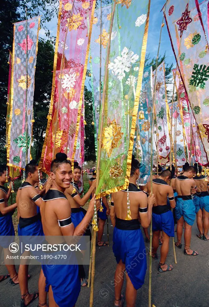 Portrait of a smiling man in a parade of colourful flags during the festival of Loy Krathong at Sukhothai, Thailand, Southeast Asia, Asia
