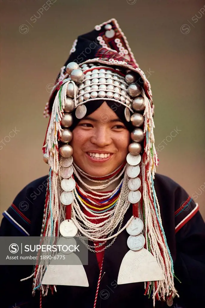 Portrait of a smiling woman of the Akha hill tribe wearing head_dress of silver and coins, in the Golden Triangle, Thailand, Southeast Asia, Asia