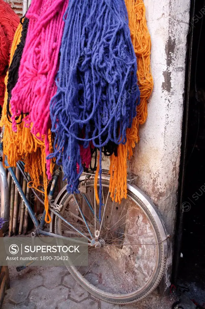 Brightly dyed wool hanging over bicycle, Marrakech, Morrocco, North Africa, Africa