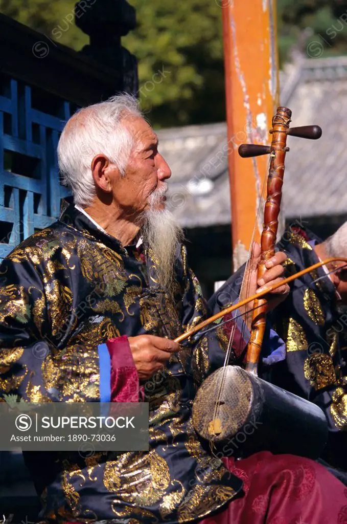 Portrait of an elderly musician from the Naxi orchestra practising by the Black Dragon Pool, Lijiang, Yunnan Province, China, Asia