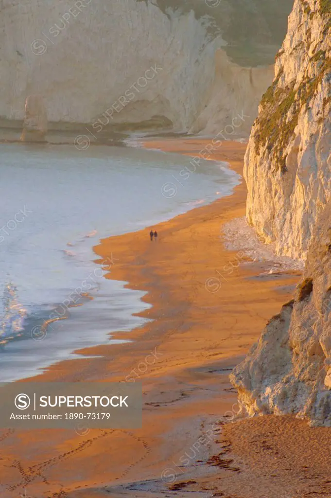 Couple walking on beach. Isle of Purbeck, Dorset, England UK