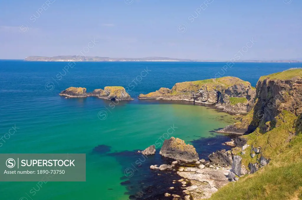 Carrick Island in Larrybane Bay, with a limestone headland, and Rathlin Island in the background, on the North Antrim Causeway Coast Way, County Antri...