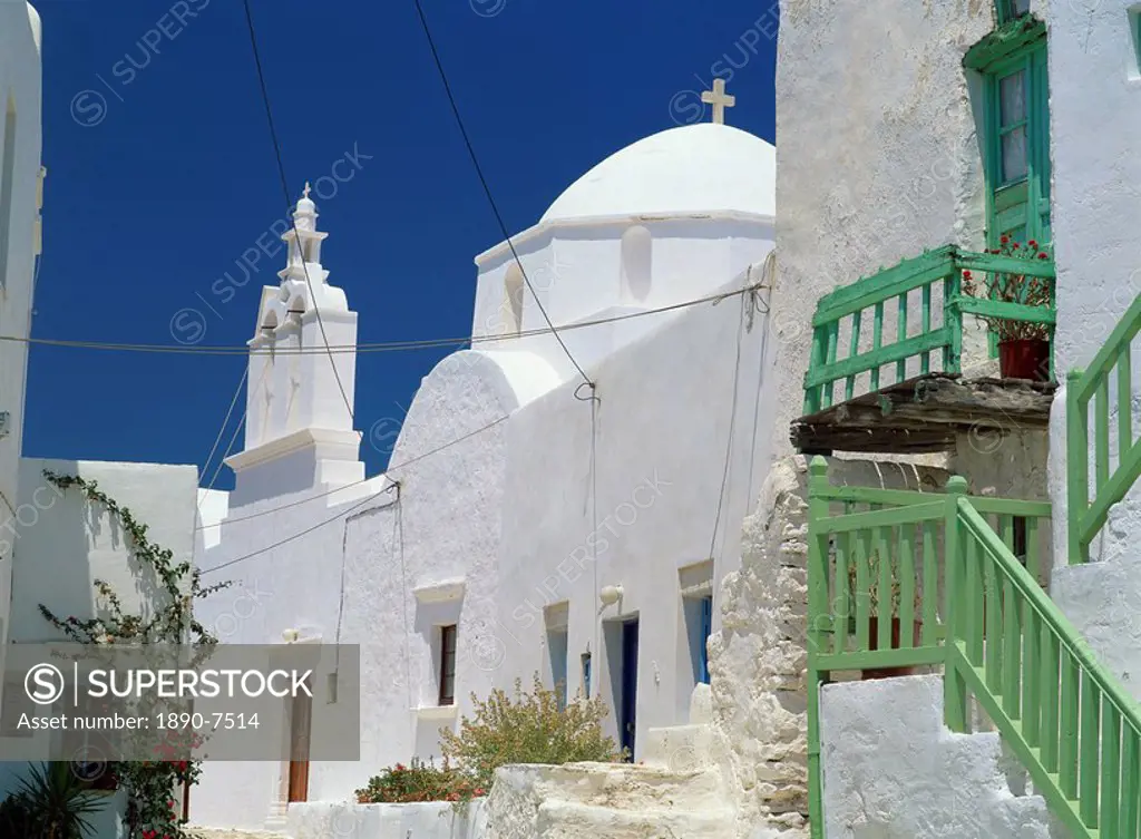 Close_up of green balcony with whitewashed walls, dome and bell tower of church beyond in The Kastro village, Folegandros, Cyclades, Greek Islands, Gr...
