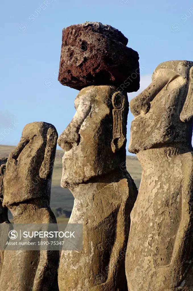 Three of the fifteen huge moai statues standing with their backs to the ocean, restored by archaeologists after destruction in 1960 by a tidal wave, A...