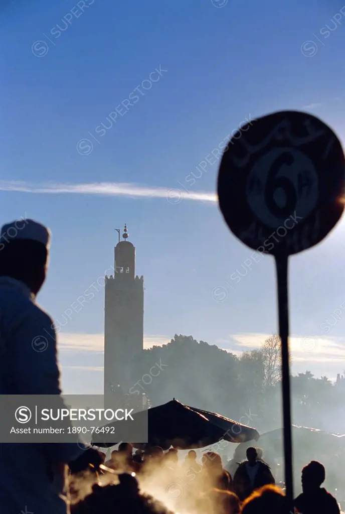 A chef cooking at a food stall in the Djemma_el_Fna square, with the Koutoubia minaret behind, Marrakech, Morocco
