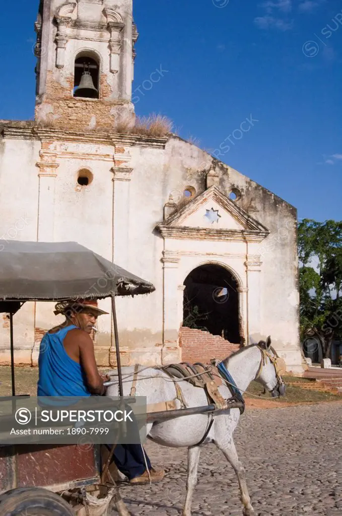 A man with horse and buggy passing an old church in Trinidad, Cuba, West Indies, Central America