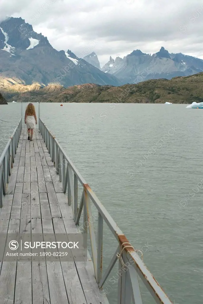 Blonde woman walks to the end of dock on Lago Grey, Torres del Paine, Chile, South America