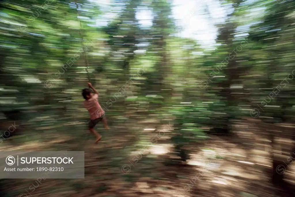 Local boy swings on vine, Corcovado National Park, Peninsula de Osa, Costa Rica, Central America