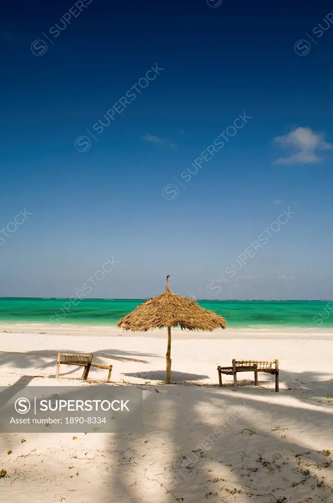 A thatched umbrella and traditional coconut wood sunbeds on Paje Beach, Paje, Zanzibar, Tanzania, East Africa, Africa
