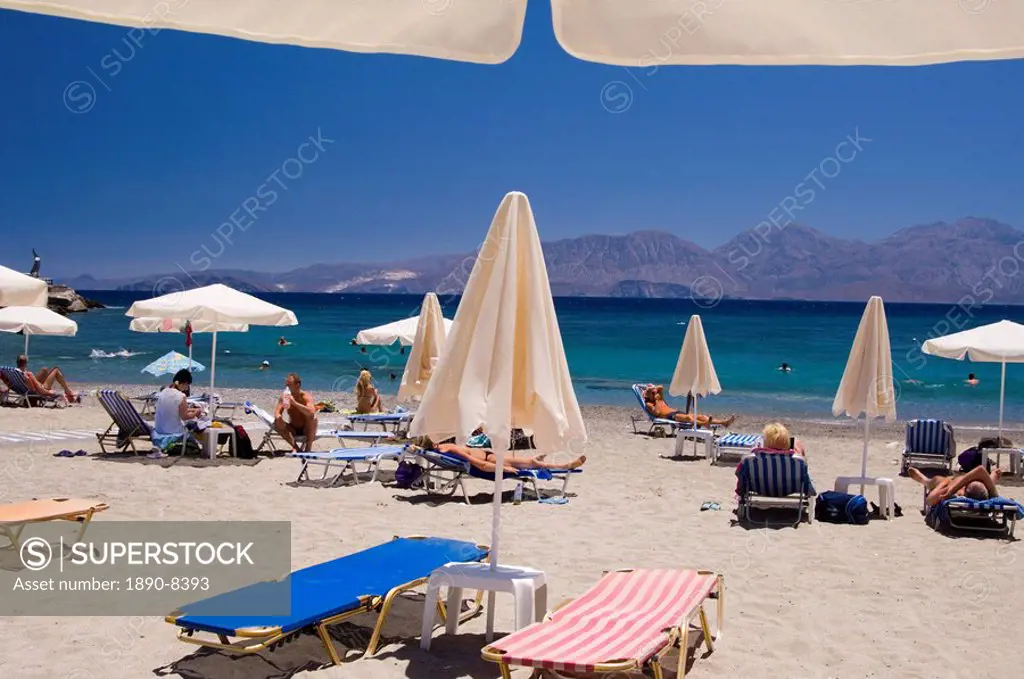 Umbrellas on the beach at Kitroplatia, a small cove outside Agios Nikolaos, Crete, Greek Islands, Greece, Europe