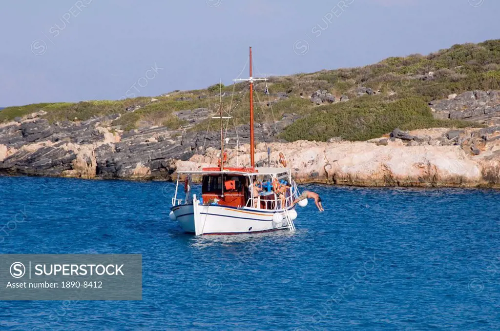 A boy diving off a boat near the island of Spinalonga near Elounda, Crete, Greek Islands, Greece, Europe