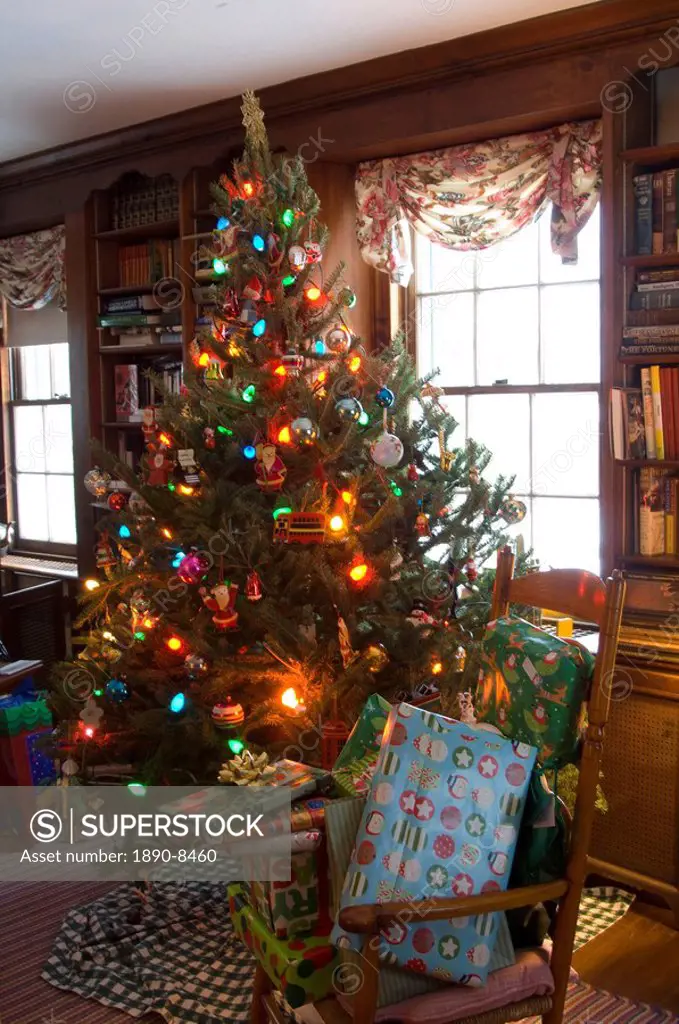 A Christmas tree decorated with lights and ornaments surrounded by gifts on Christmas morning, United States of America, North America