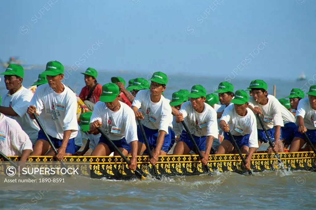 Men wearing baseball caps rowing a boat during the Water Festival in Phnom Penh, Cambodia, Indochina, Southeast Asia, Asia