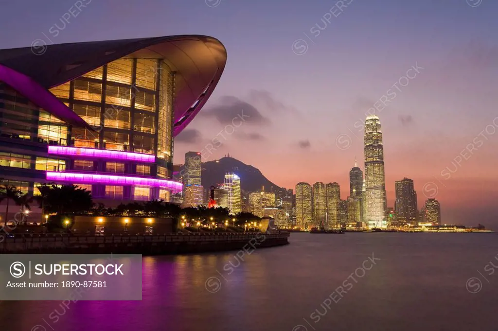 Hong Kong Convention and Exhibition centre illuminated at dusk with the International Finance Centre building and financial district in the background...