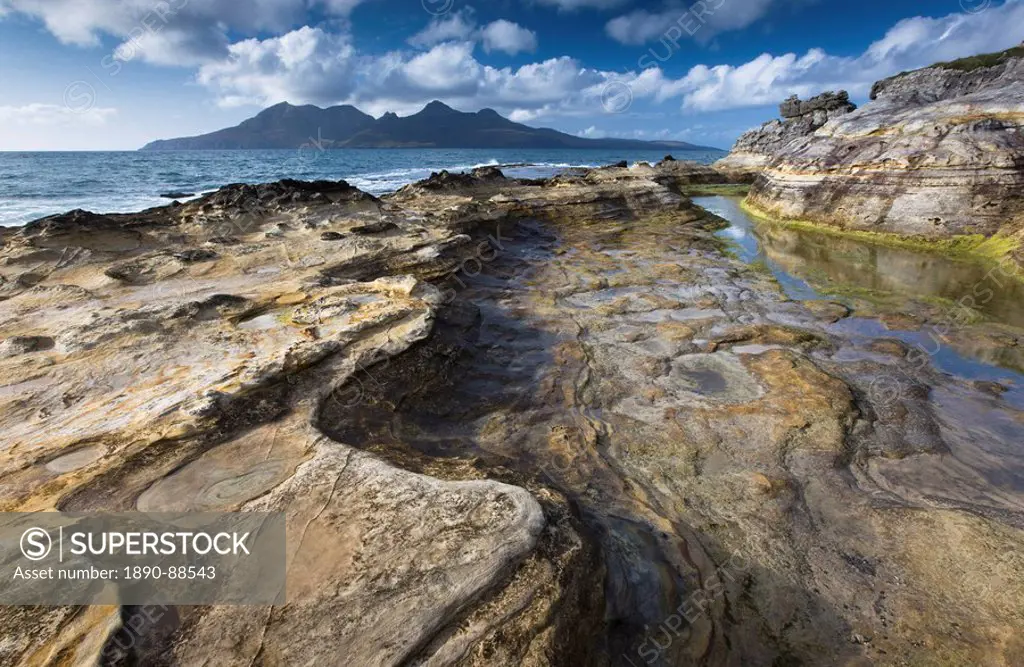 View towards Isle of Rum from rock formations at Laig Bay, Isle of Eigg, Inner Hebrides, Scotland, United Kingdom, Europe