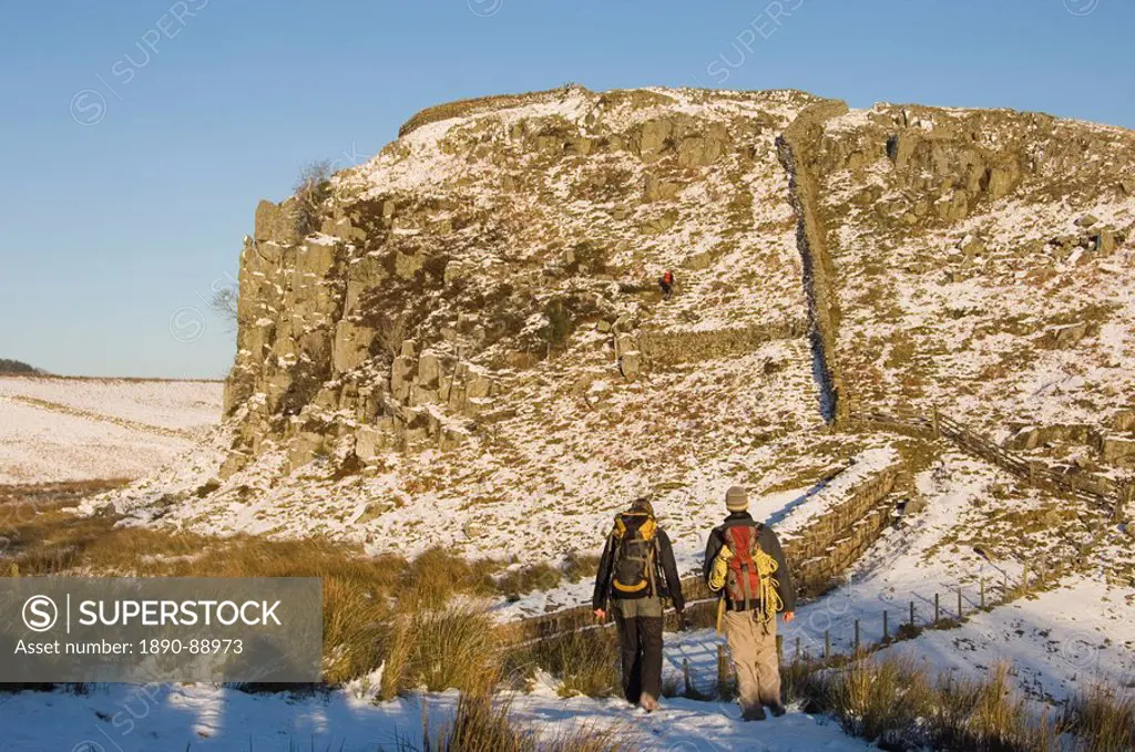 Two climbers head for the crags at Steel Rigg, Hadrians Wall, UNESCO World Heritage Site, Northumbria, England, United Kingdom, Europe