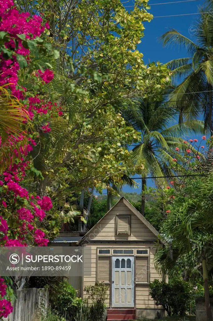 A traditional chattel house surrounded by bougainvillea and palm trees in Barbados, The Windward Islands, West Indies, Caribbean, Central America