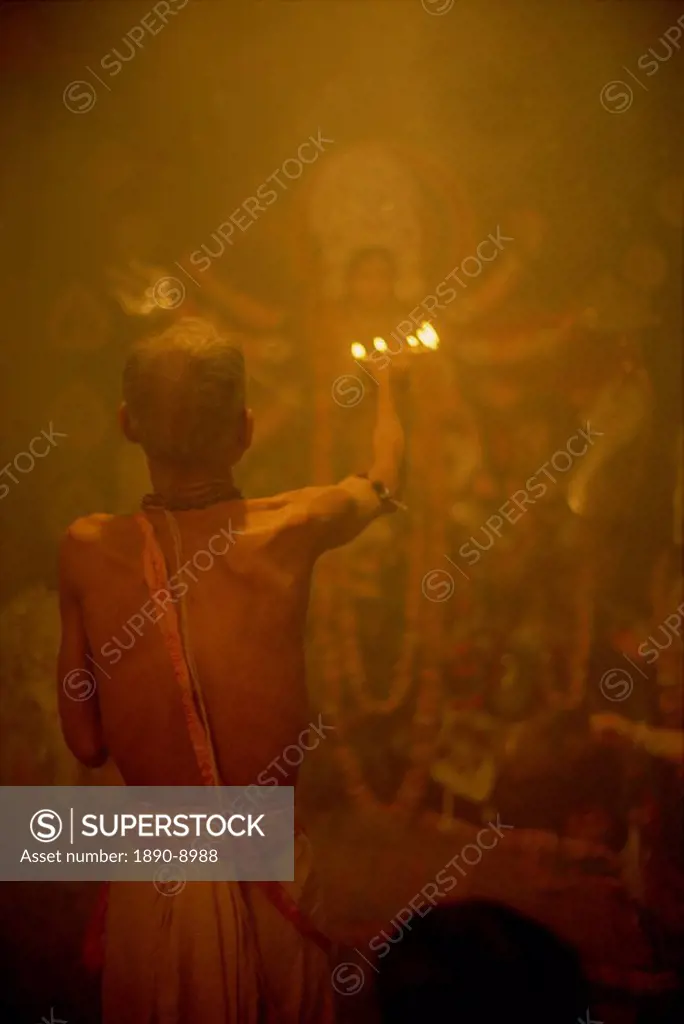 Temple priest before the image of the ten armed warrior goddess Durga, Durga Puja Festival, Varanasi, Uttar Pradesh state, India, Asia
