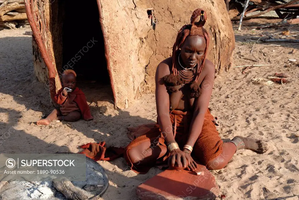 Woman of the Himba tribe grinding pigment for body decoration, Kaokoland, Namibia, Africa
