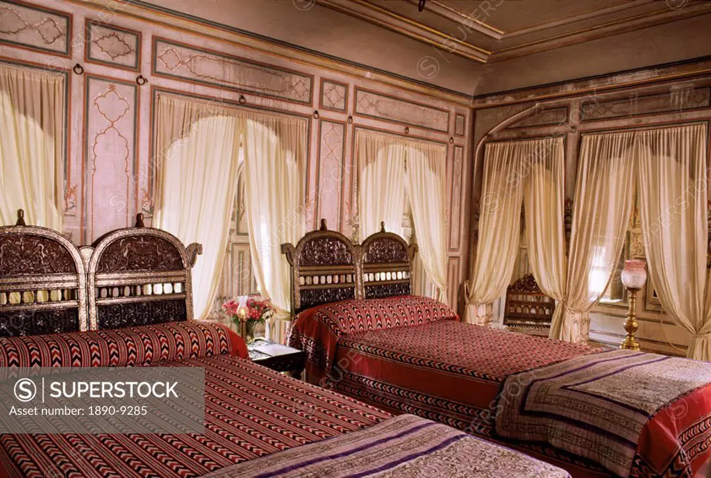 Traditional wood carved headboards and block printed fabrics in guest bedroom, Samode Haveli, Gangapol District, Jaipur, Rajasthan state, India, Asia